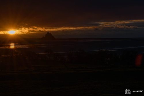 Le Mont-Saint Michel se dresse dans le halo lumineux.